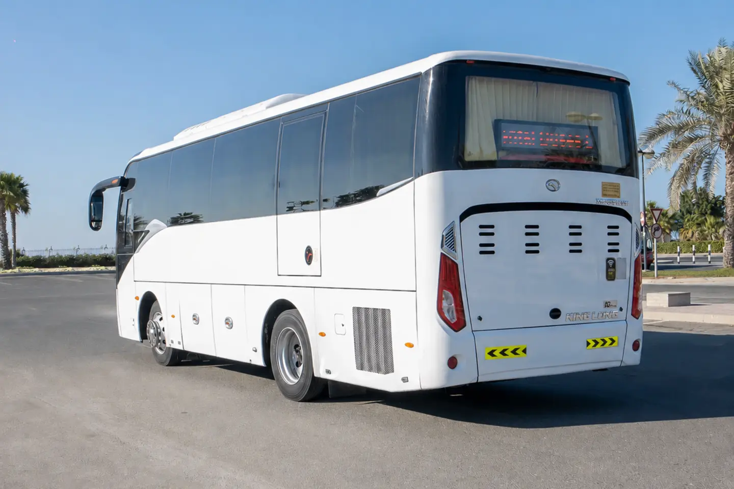 Illustrative rear and side view of a white private coach for a Dubai 35-seater bus with driver enquiry